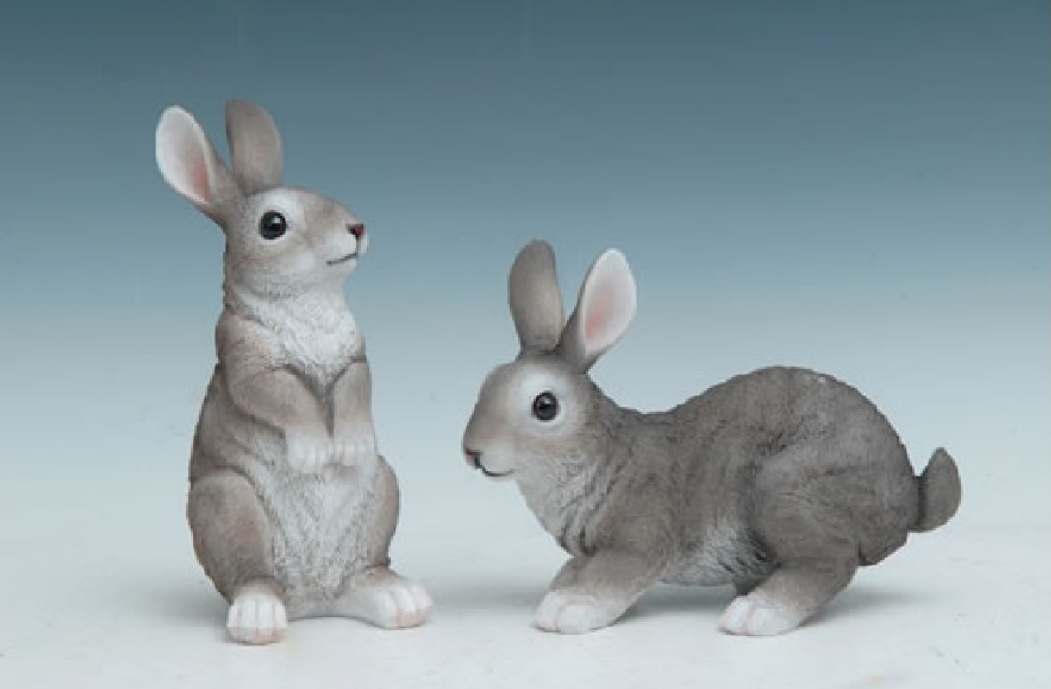 Two gray rabbit figurines on a gradient blue and white background