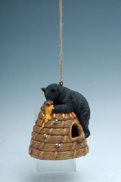 Decorative birdhouse with a black bear on a beehive.