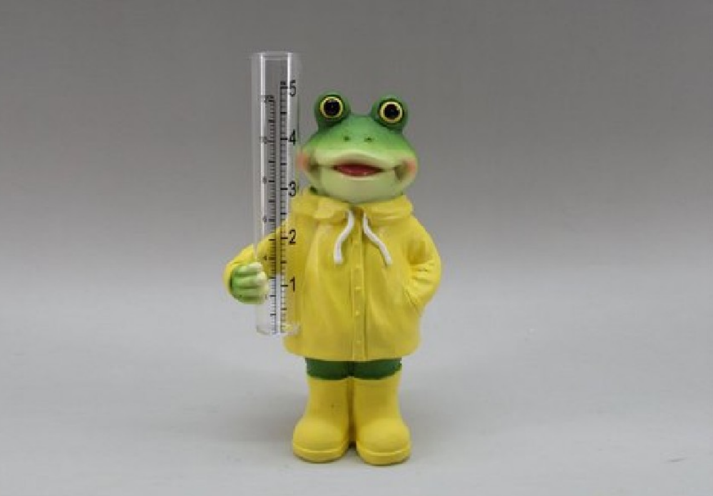 Frog figurine in a yellow raincoat holding a ruler on a gray background